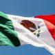 Close-up of the Mexican flag waving in the wind, showing the national emblem with the eagle, snake, and cactus.
