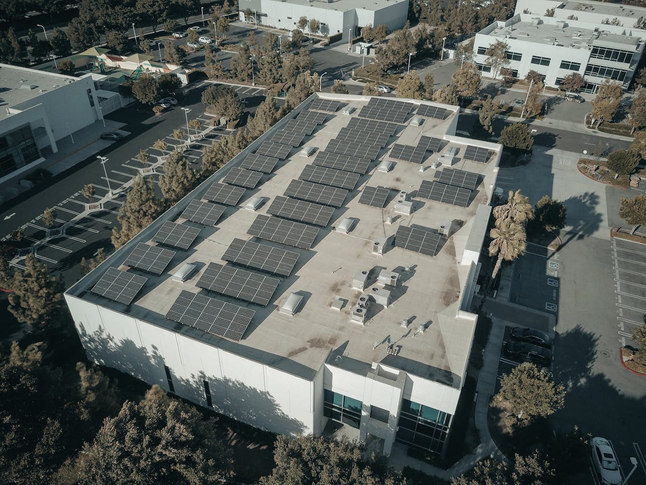 Aerial view of an industrial park building equipped with solar panels on the rooftop.