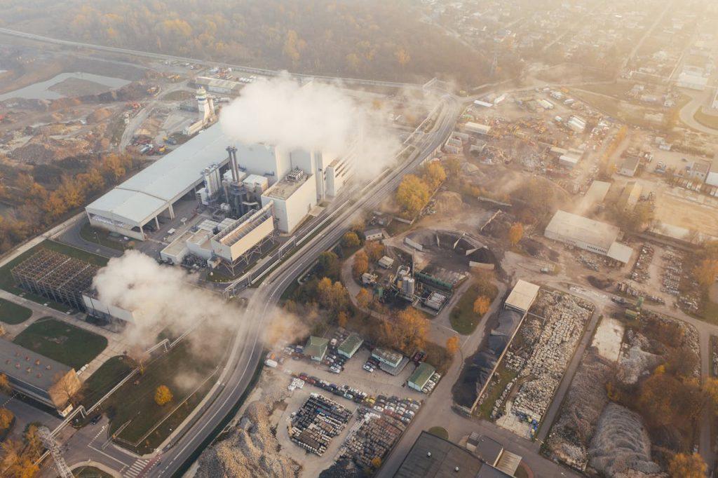 Aerial view of an industrial facility with visible emissions illustrating environmental impact and the importance of COA reporting compliance in Mexico.