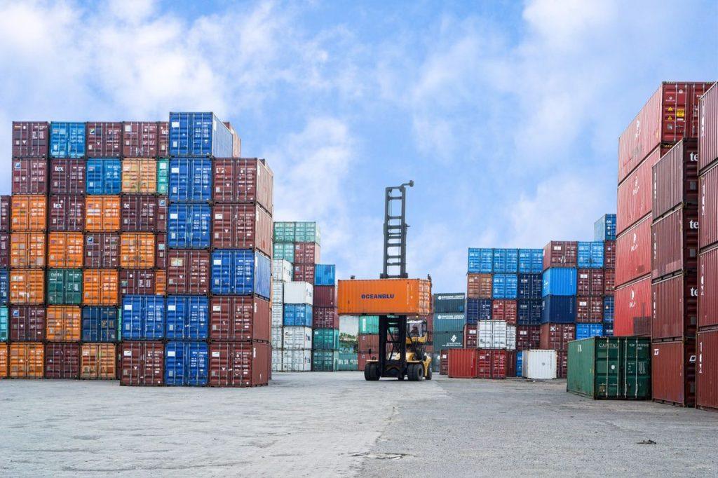 Stacked shipping containers at a logistics yard, representing import/export operations under the shelter model in Mexico