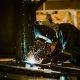 Welder working on steel fabrication, representing metallurgical industries subject to COA reporting requirements in Mexico