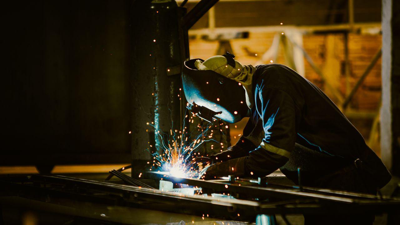 Welder working on steel fabrication, representing metallurgical industries subject to COA reporting requirements in Mexico