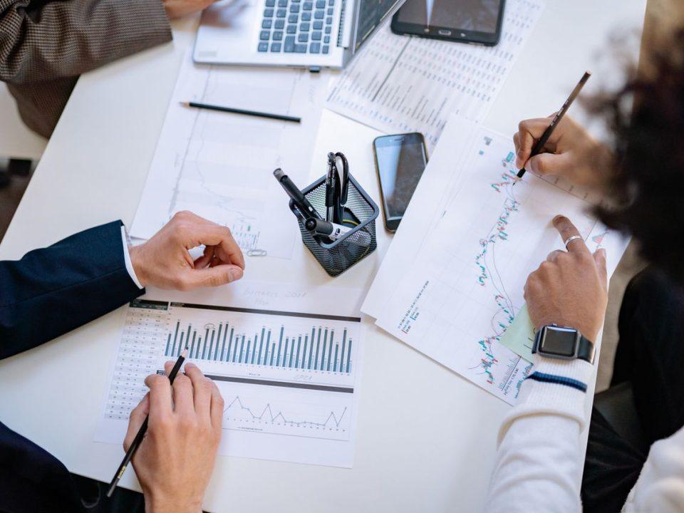 Business professionals reviewing operational and financial reports while planning manufacturing operations and market entry in Mexico.