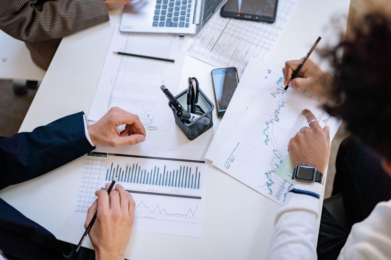 Business professionals reviewing operational and financial reports while planning manufacturing operations and market entry in Mexico.