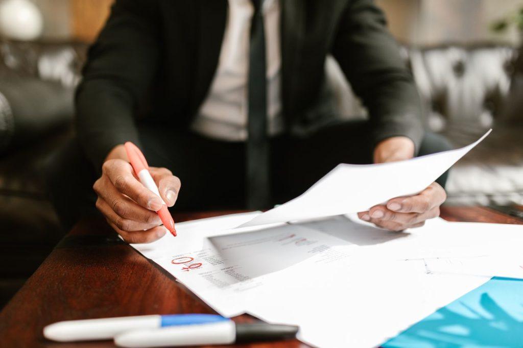 Business professional reviewing and marking corporate documents as part of bank account signatory verification in Mexico
